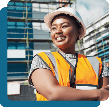 A female construction worker smiles while on a job site, representing a Sierra Pacific member