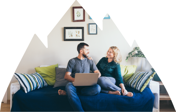 Couple sites on a couch with a laptop