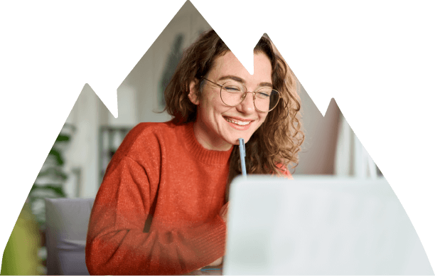 Smiling girl working on laptop in living room.