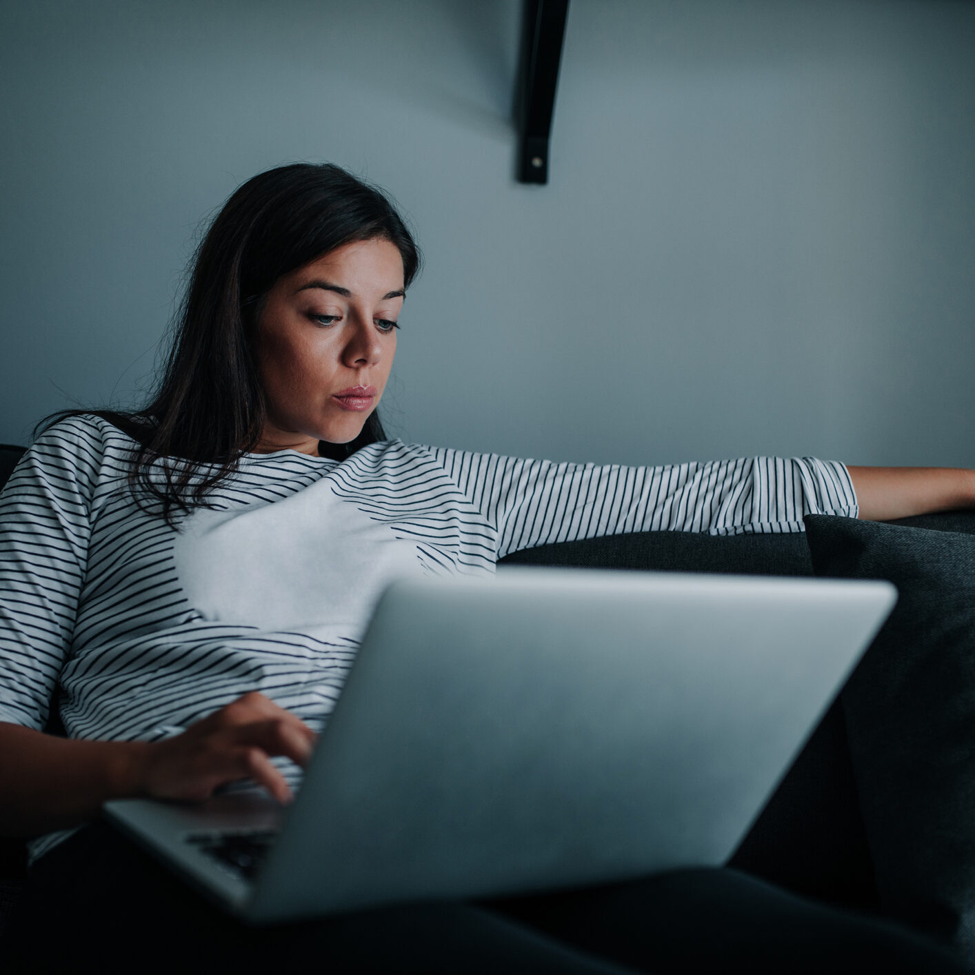 Woman working on a laptop at home, stressed out